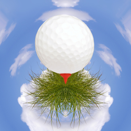Golf ball on tee rests on grass with small planet sky in backgroundの写真素材