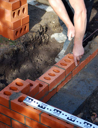Construction worker lays bricks building house extension.の写真素材