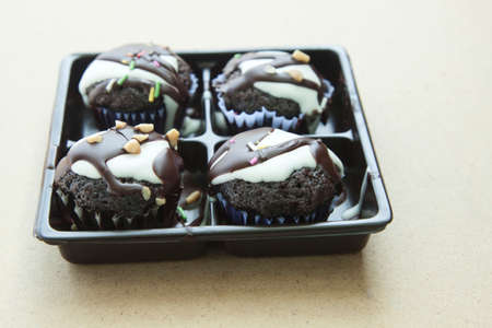 This dark brown brownie topped with chocolate and nuts makes it even more appetizing on the light brown wood floor, shot in the morning in natural light from above.の写真素材