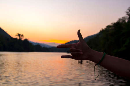 Three finger symbol The mother finger, the index finger and the little finger symbolize love and peace on the mountains, rivers and the blue background is a land full of tourists.の写真素材