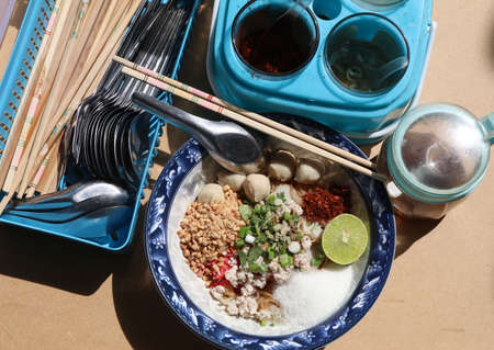 Tom Yum Pork Noodles with Pork Balls - Chilli and Lemon Juice - Cayenne - Peanuts, taken in the afternoon and shaded by sunlight.の写真素材