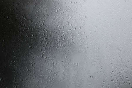 Raindrops on a black background Water droplets on a dark background Rain protection glass for cars that fall in the evenings that storm enter.の写真素材