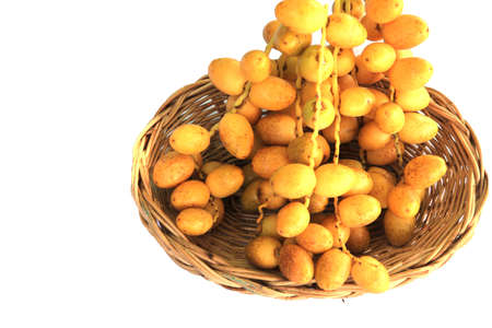 Ripe yellow dates are organically grown, sweet and delicious, and fresh in woven baskets - on a white background.の写真素材