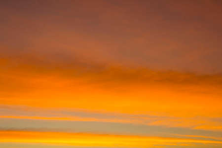 The sky is a horizontal line of yellow-orange and colorful colors in the beautiful evening in the midst of nature which is peaceful, warm and romantic in the countryside and is extremely beautiful.の写真素材