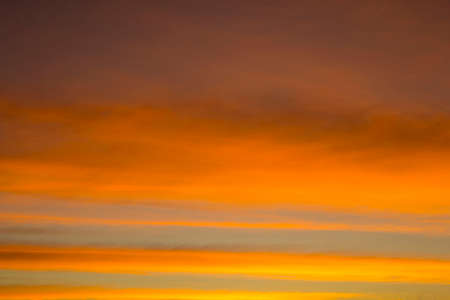 The sky is a horizontal line of yellow-orange and colorful colors in the beautiful evening in the midst of nature which is peaceful, warm and romantic in the countryside and is extremely beautiful.の写真素材