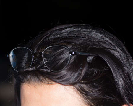 Eyeglasses - wrapped on a girl's head on top of her head - in the noble night resting - with a shadow reflecting through the eyeglasses - short-term.の写真素材
