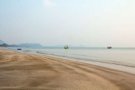 The beach is quiet in the evening, the sky is light blue, no people, suitable for resting, walking, exercising, see the fishing boat parked in the sea, near the longest shore.の写真素材
