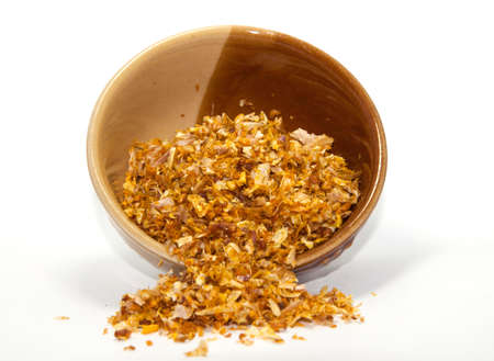 Fried garlic for topping and adding flavor and decorating food to make it more appetizing. It is a popular spice and herb that people around the world consume on a white background in a cup.の写真素材