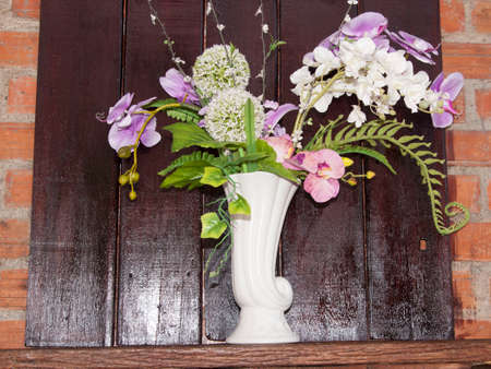 Vases and flowers on the background, dark brown wood panels and red brick walls that are located in the cafes' doors decorated in an old-fashioned style.の写真素材