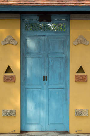 blue wooden door of a house designed and decorated in Balinese style is beautiful and durable yet has a designer design that is perfect and private.の写真素材