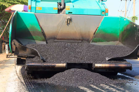 Machines are pouring asphalt on roads under construction and repair. And new construction makes traveling in the countryside of Thailand more comfortable.の写真素材