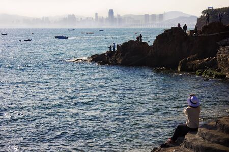 Woman sitting on the reef fishingのeditorial素材