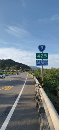 Bicycle lane on mountain road with blue sky and cloud background.
