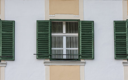 windows with open old green blinds, closed glass windwos,