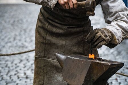 Blacksmith working on metal on anvil at forge high speed detail shotの写真素材