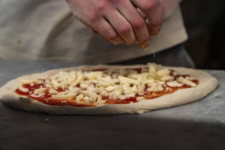 Appetizing background tomato and mozzarella pizza closeup filling the frame ready to cookの写真素材