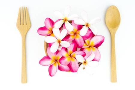 Topview Plumeria in wooden bowl spoon and frok isolated on white backgroundの写真素材