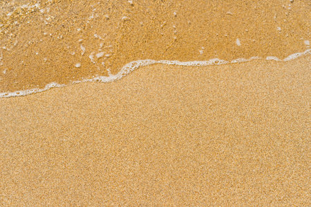 Beautiful crystal clear sea water, Gentle waves breaking on golden sand beach. From above with copy...