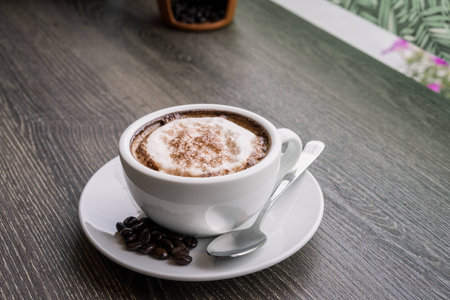 Coffee cup and coffee beans on wood table ,warm and good smellの写真素材