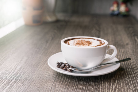 Coffee cup and coffee beans on wood table ,warm and good smellの写真素材