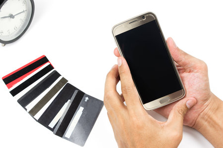 Online payment Concept. Man using credit card and Office desk table with clockの写真素材