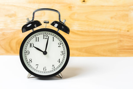 alarm clock on white table and wood wallの写真素材