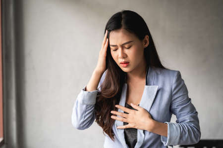 Pandemic virus, Asian woman have a cold and symptoms coughing, fever, headache and painsの写真素材