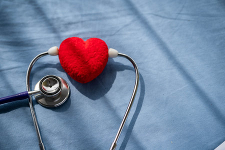 Medical stethoscope and red heart on Patient's bed.Concept healthcare.の写真素材