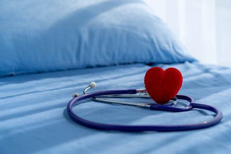 Medical stethoscope and red heart on Patient's bed.Concept healthcare.の写真素材