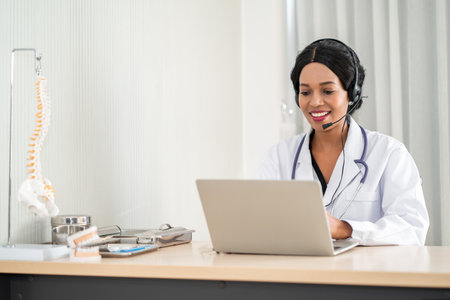 Portrait of african american happy smiling young doctor in headset consulting patient over the phone. Health care call center online conceptの写真素材