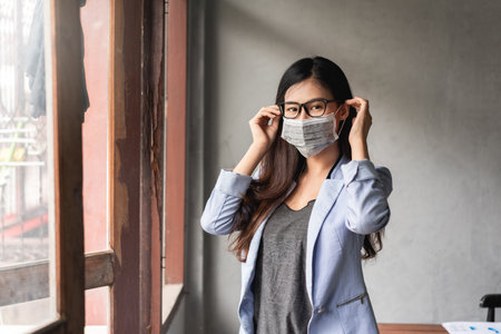 Asian woman have a cold and symptoms coughing, fever, headache and painsの写真素材