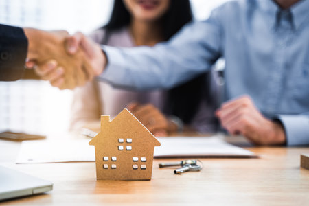 House model with real estate agent and customer contract to buy house and handshake after make a contactの写真素材