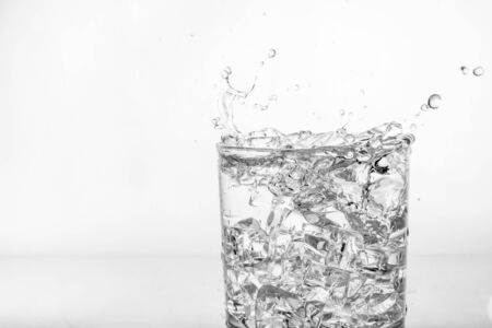 Splashing of water with ice in glassの写真素材