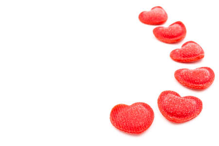 Red heart-shaped sugar sprinkles on white backgroundの写真素材