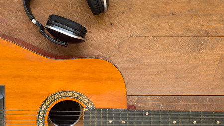 Top view workspace with headphone and acoustic guitar on wooden table background .Free space for your text.の写真素材