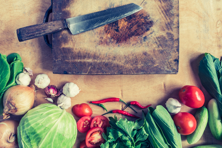 Top view of knife on wooden chopping block with Fresh vegetables.の写真素材