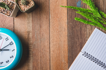Top view of Blank notebook with clock,paddy rice and cactus on wooden table background. Free space for textの写真素材