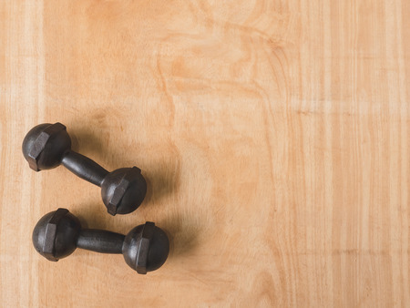 Top view of iron dumbbells or exercise weights on wooden table background. Free space for textの写真素材