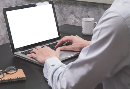 Close up of Businessman working on Laptop on the black desk.