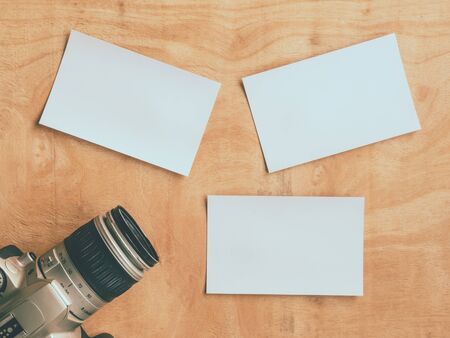 Top view of camera with blank postcards on wooden table background.の写真素材