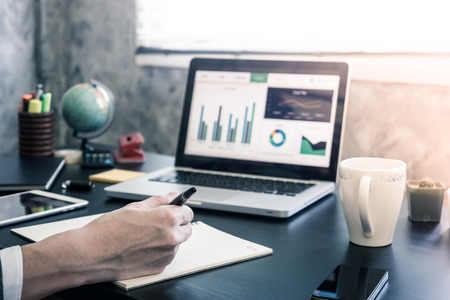 Businessman analyzing investment charts on the office desk.の写真素材