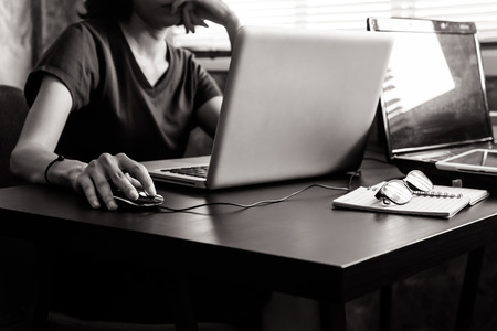 Casual young woman using a laptop on the desk. Black and White toneの写真素材