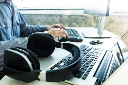 Male hands working on computer with headphones, Sound engineer conceptの写真素材