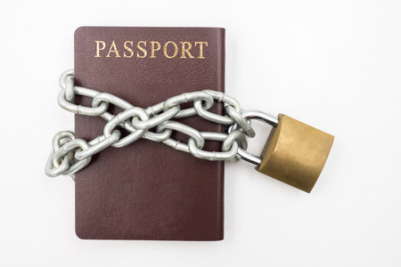 Passport with chain and padlock on white background, Illegal Immigration Conceptの写真素材