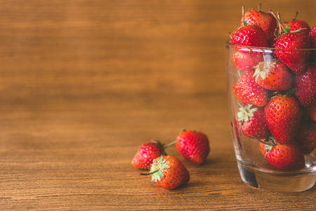 Fresh strawberries in glass on the wooden table background.の写真素材