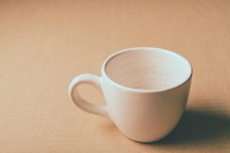 Empty white cup on wooden table background.の写真素材