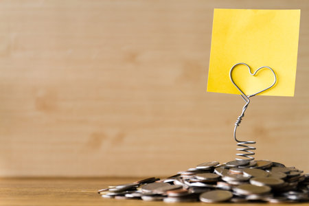 Pile of coins with blank label on a wooden table. Financial Concept. Selective focus. Free space for textの写真素材