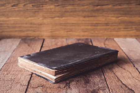 Old hardback book on wooden table.の写真素材