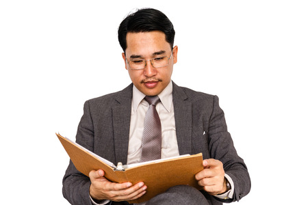 Businessman with hardback book on a white background.の写真素材