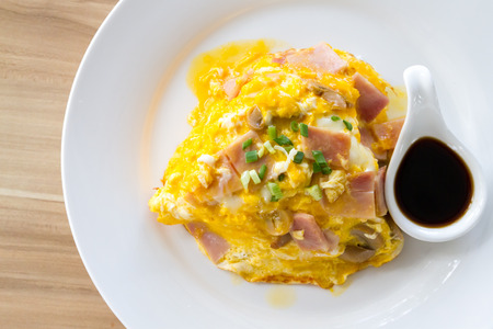 Scrambled omlette eggs with pork ham on rice.の写真素材